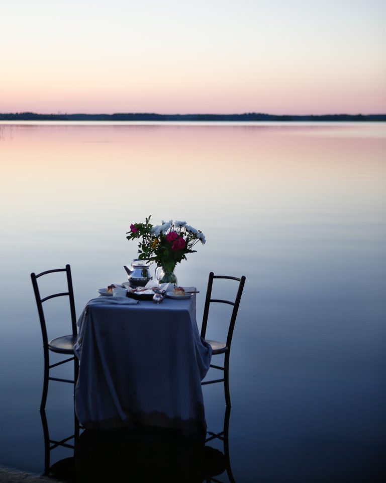 Outdoor dinner by a still lake